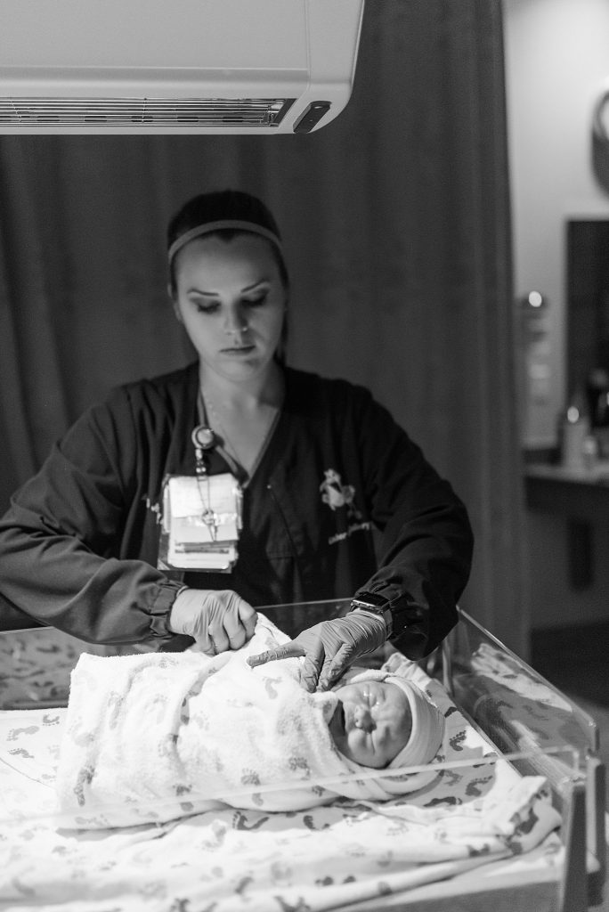 Nurse wrapping baby for the first time at Baylor after birth