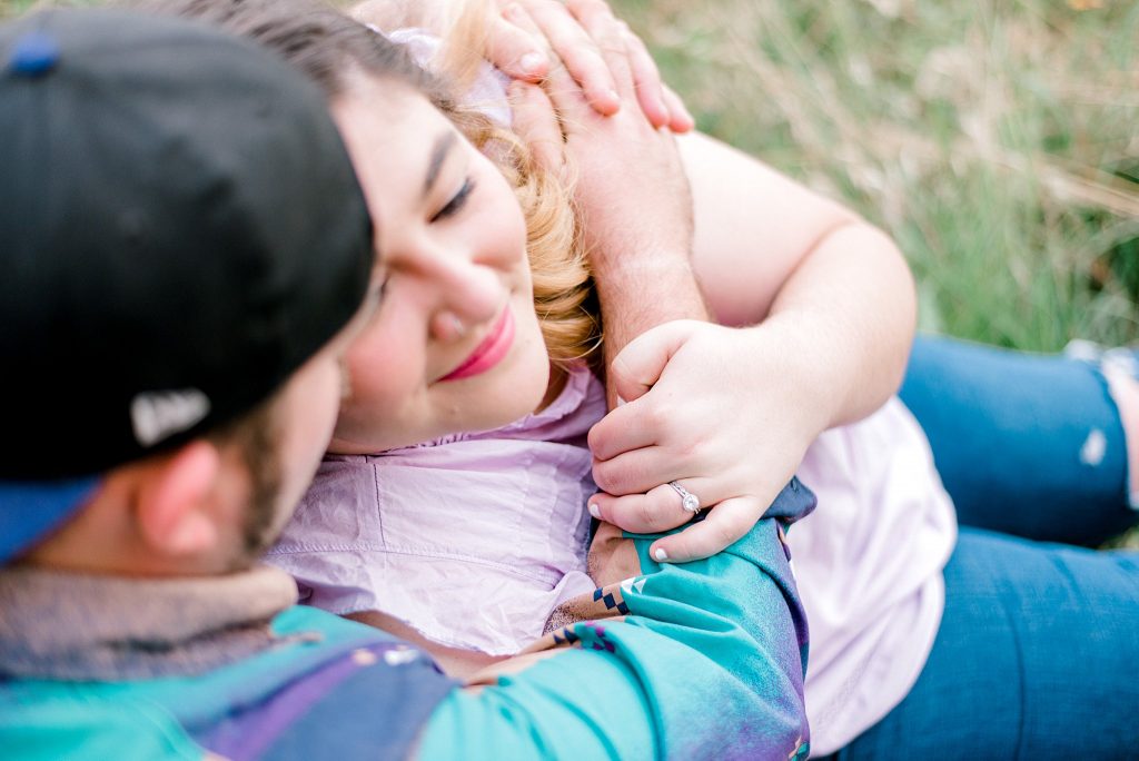 Fort Worth Engagement Session with couple sitting on hill beside the river