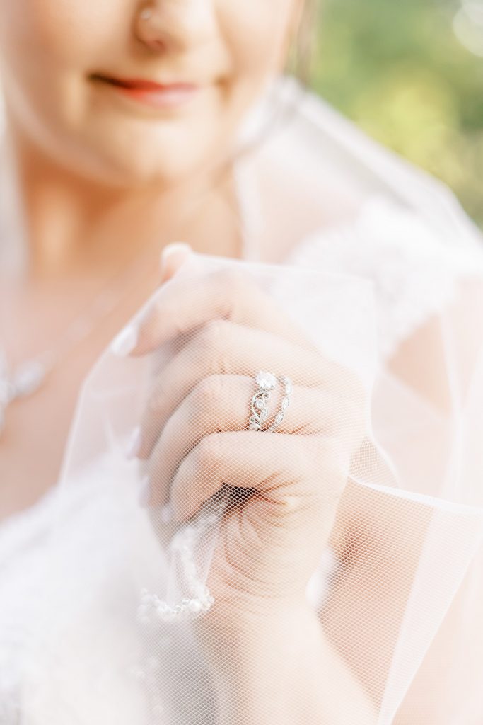 Close up of wedding rings covered by wedding veil