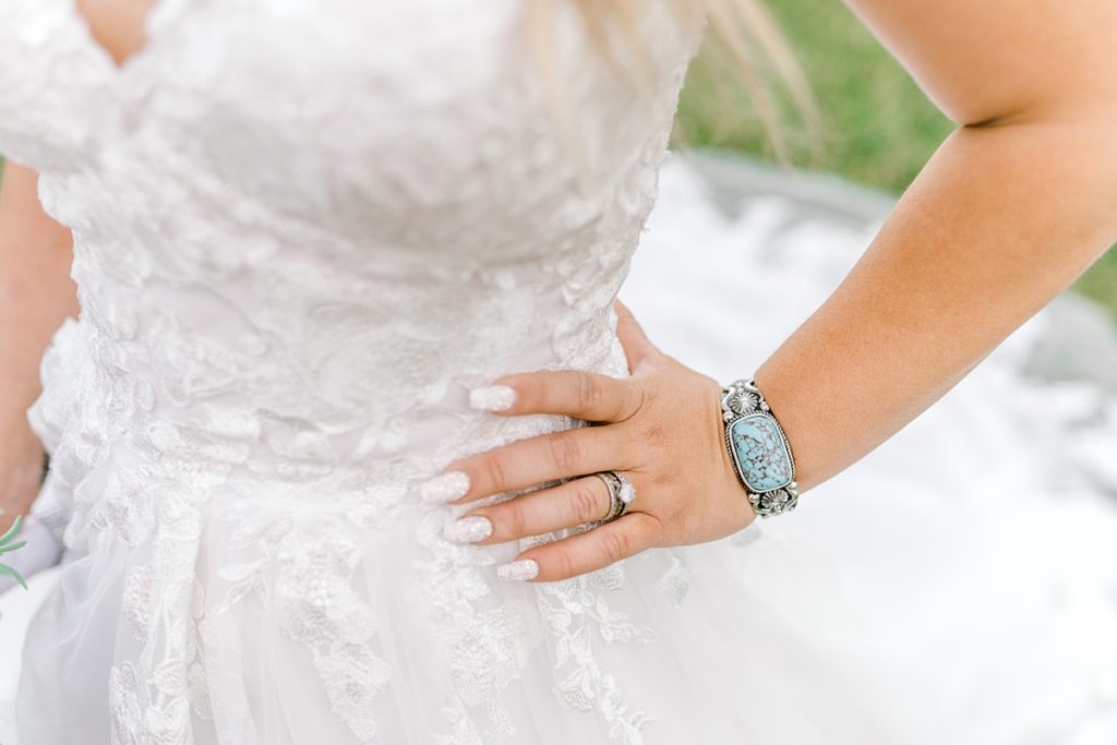 Bride showing off turquoise and silver wedding jewelry