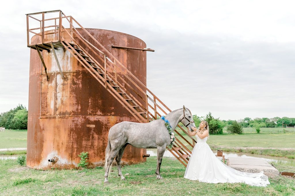 Bride standing next to tank while petting horse