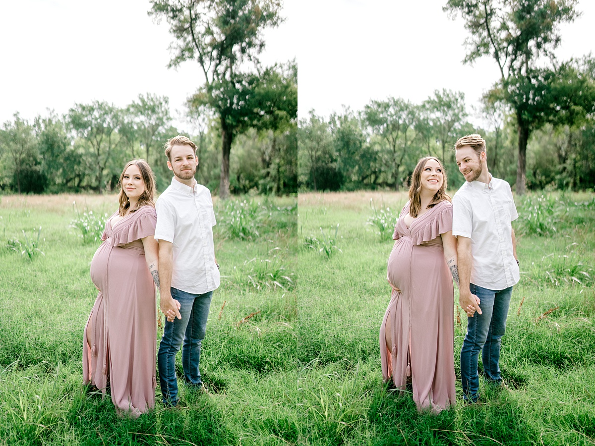 couple holding hands in field for Texas maternity session
