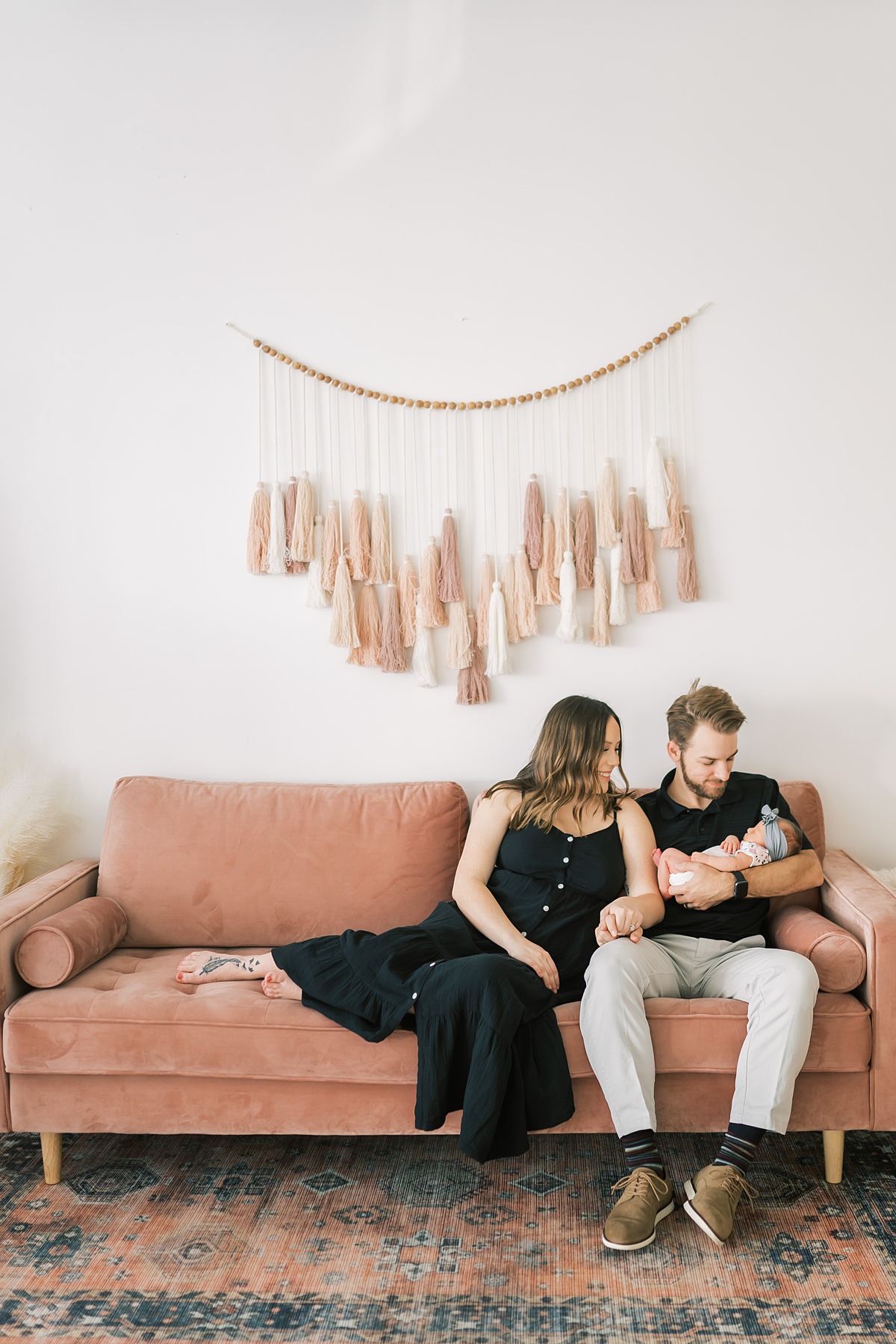 couple sitting on couch with baby in Texas newborn session