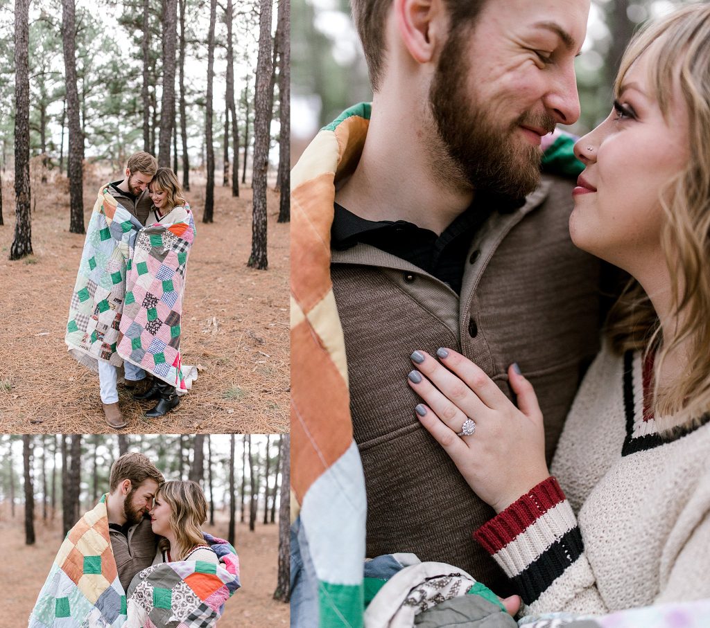 engagement photo with bride and groom cuddling in the pine trees
