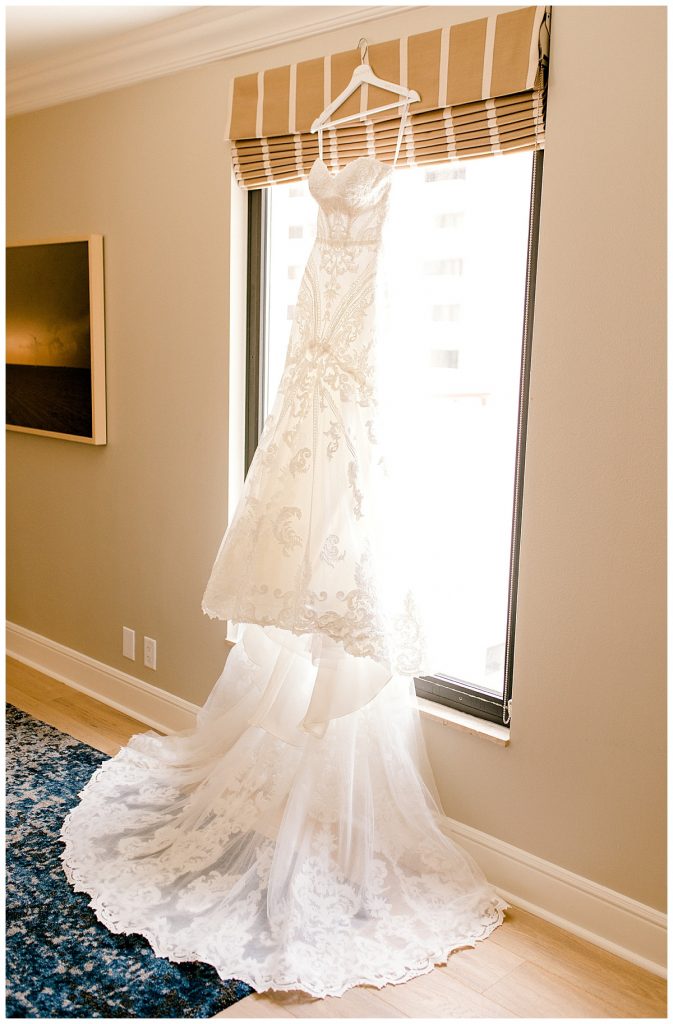 brides dress hanging in the window of The Adolphus Hotel in Dallas