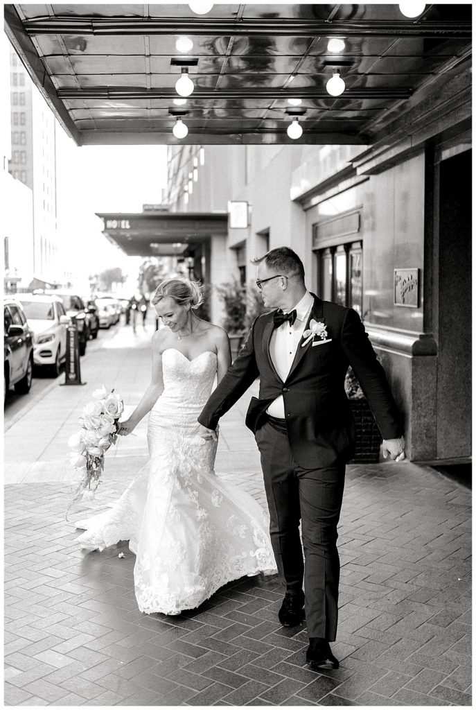 Bride and Groom walking down Main Street in Dallas | Adolphus Wedding Photographer 