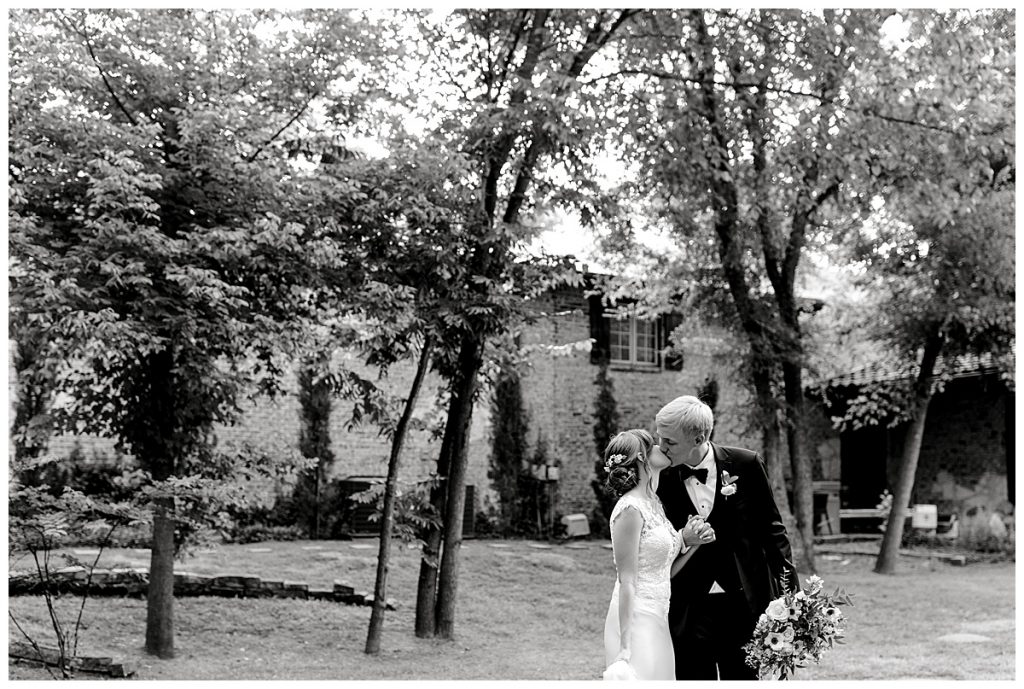 Black and white bride and groom kissing under trees- Sabel Moments Photography- Hidden Waters Events wedding- Waxachachie Texas wedding 