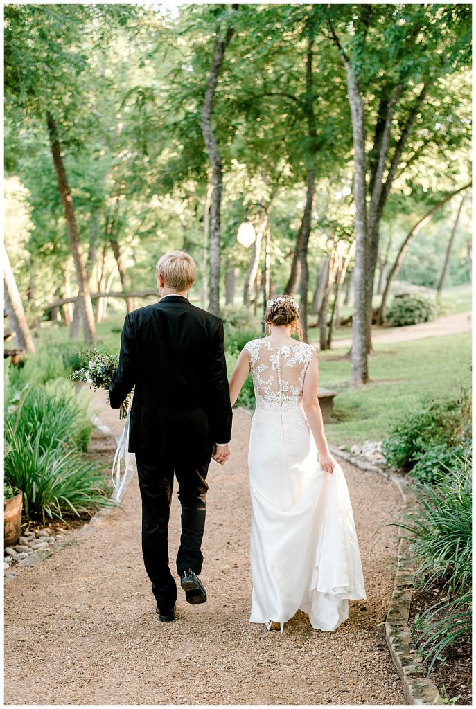 Bride and groom walking down woodsy path- Hidden Waters Events Wedding- Sabel Moments Photography- Waxachachie, Texas wedding