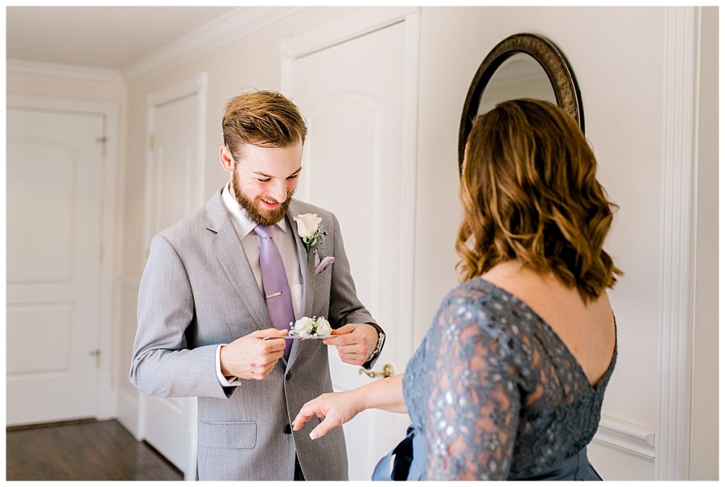 Groom putting corsage on his mother