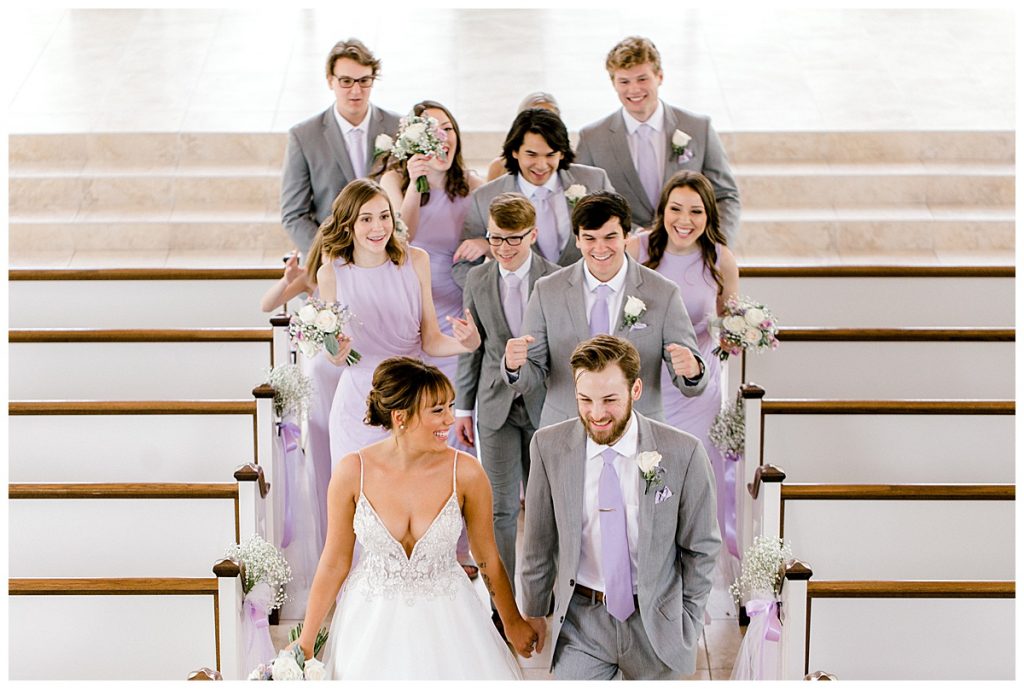 Bride and groom walk down aisle followed by bridal party