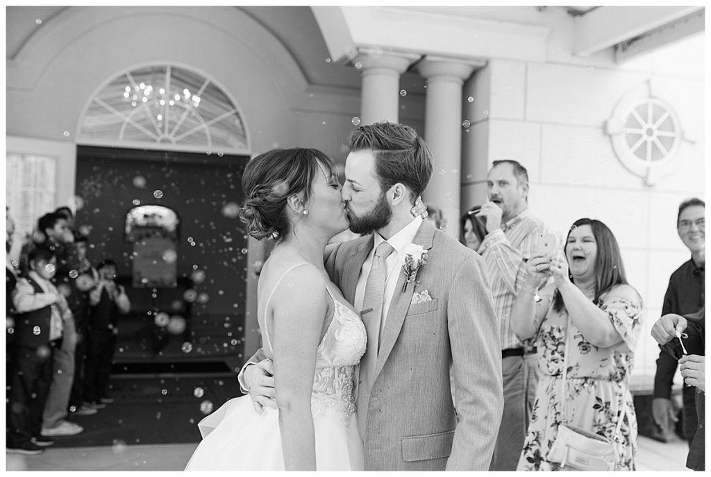 BW bride and groom grand exit kiss with bubbles