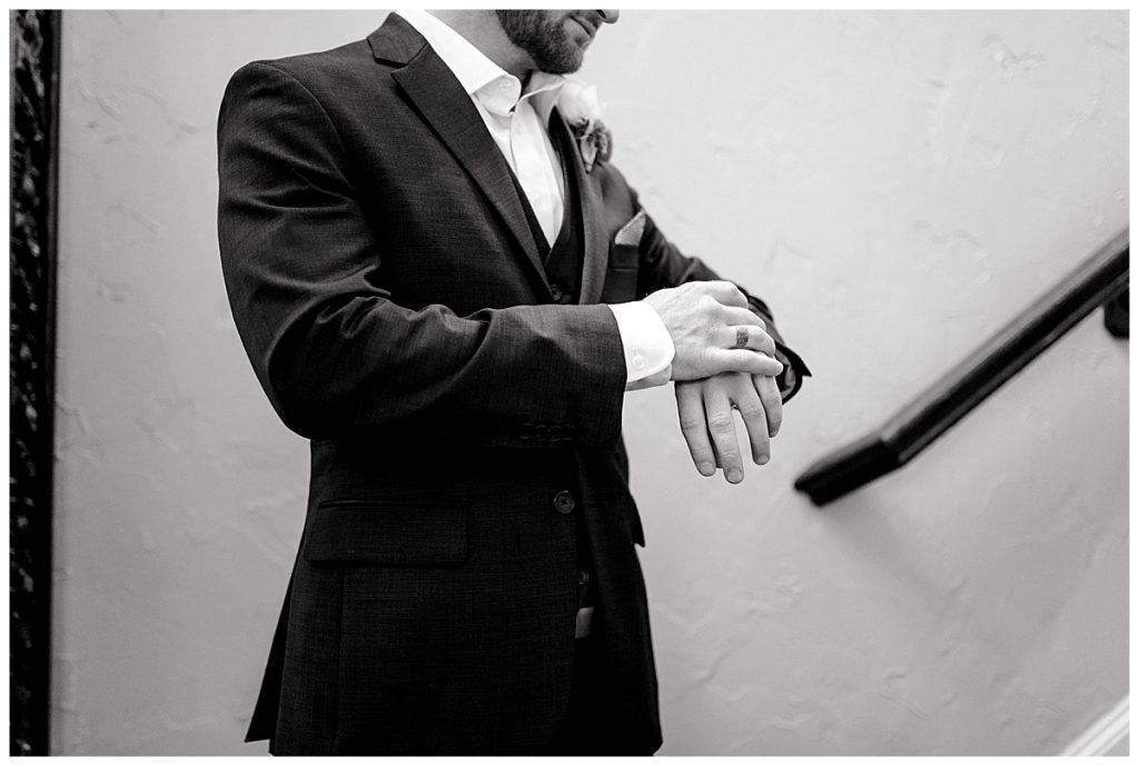 BW groom in suit checking watch