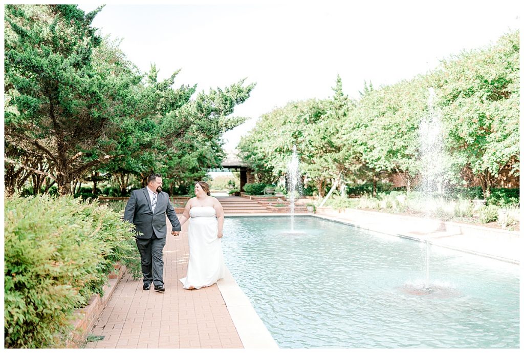 Bride and groom walk hand in hand at Clark Gardens wedding venue
