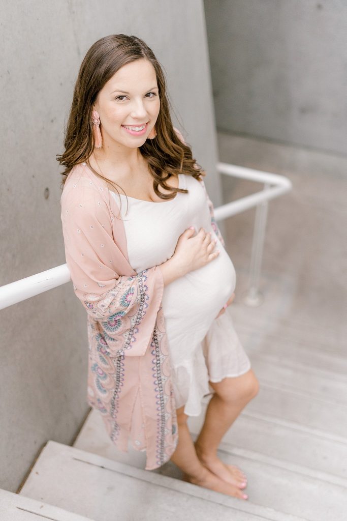 Mom posing on staircase during her maternity session 