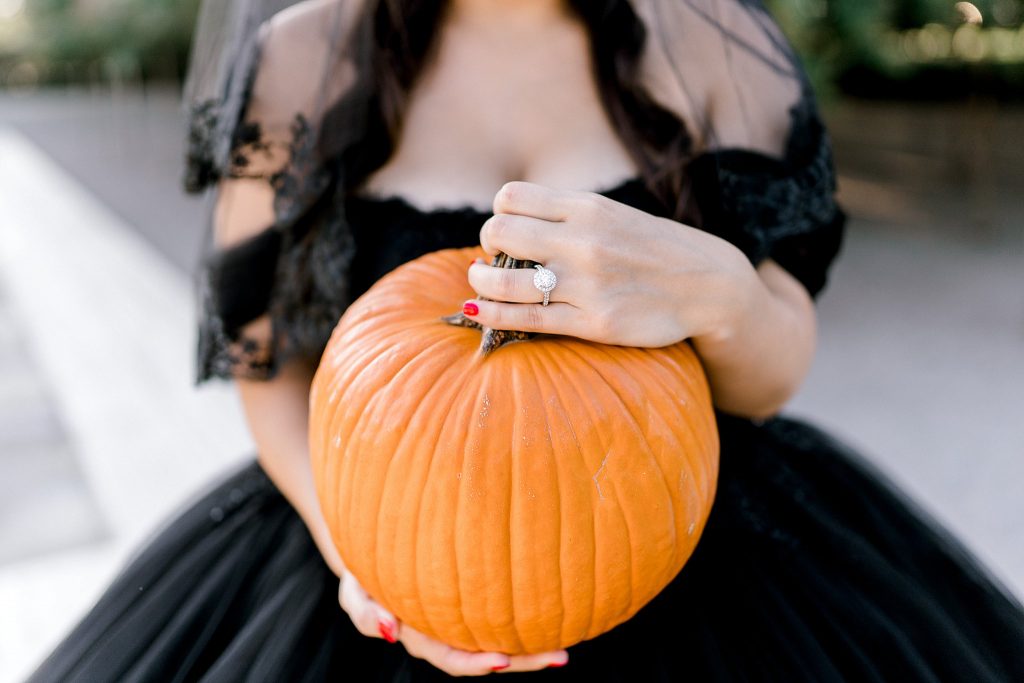Gothic bride in black wedding ballgown holding pumpkin in Fort Worth bridal session 