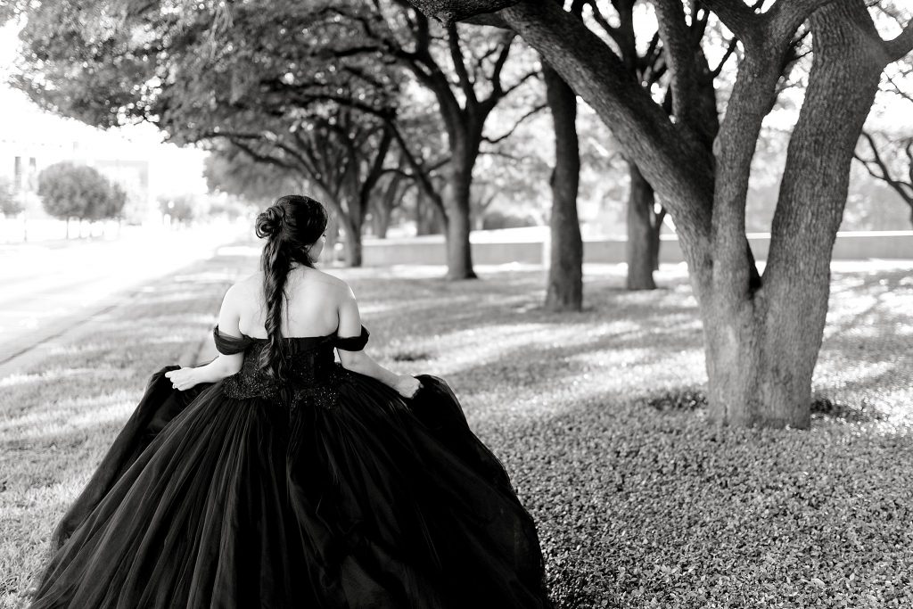 BW bride in black gown in field of trees 