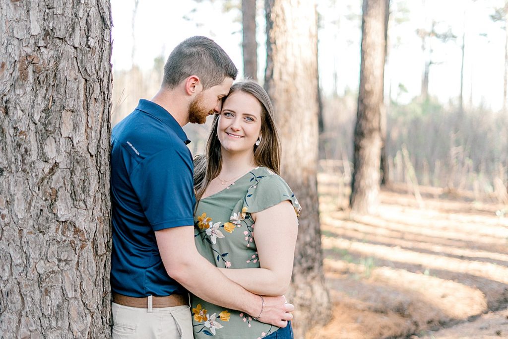 Couple embracing against tree, girl looking into camera