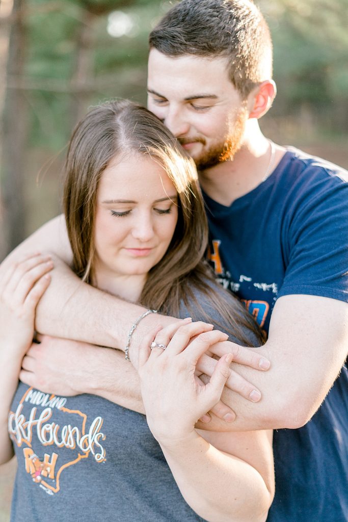 Guy hugs girl from behind in engagement session