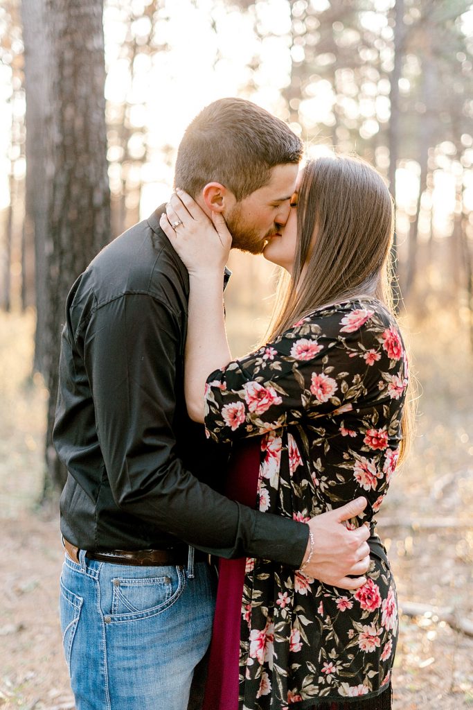 Couple kissing in woods in Texas Wildcatter Ranch engagement session