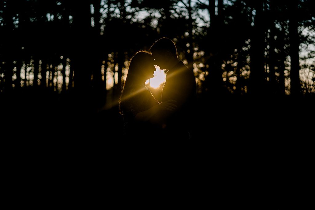 Guy and girl nuzzling at sunset with sunspot| Wildcatter Ranch Engagement
