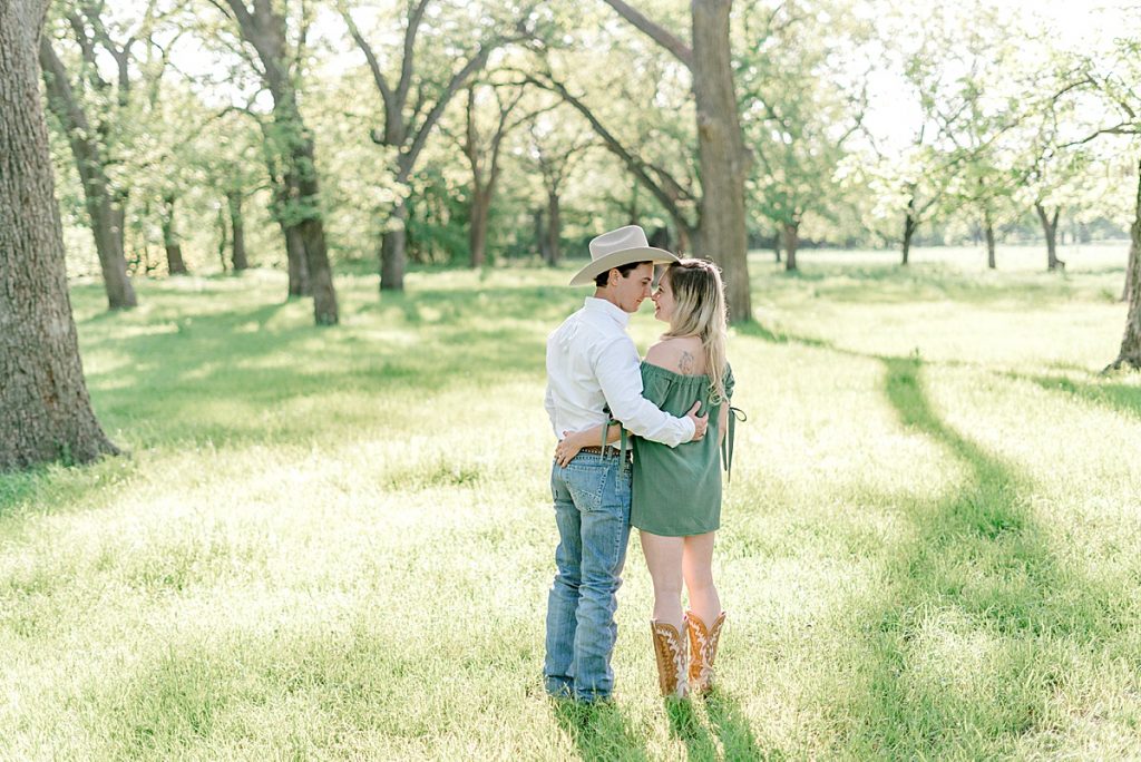 Guy and girl embrace and nuzzle noses in meadow | Hamilton/Hico Engagement 