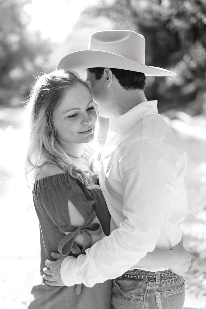 black and white girl gazing off smiling while hugging guy