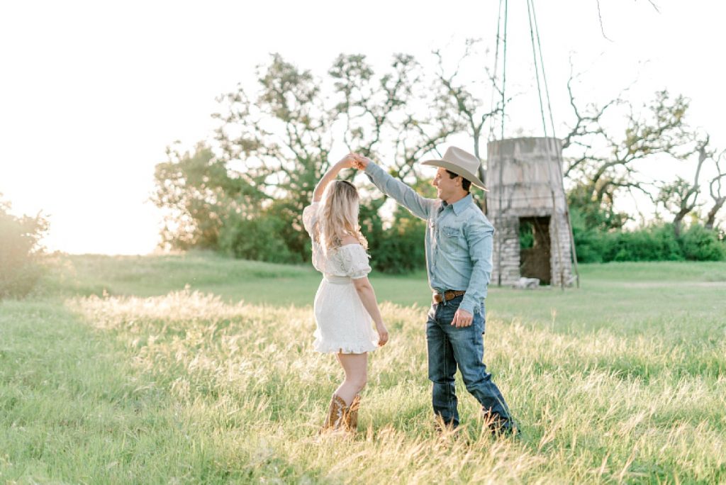 Guy twirls girl in field in sunlight during their Hamilton/Hico engagement session 