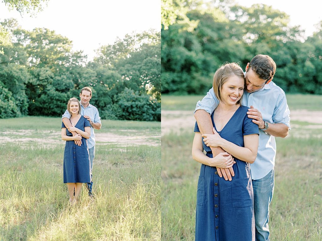 Guy standing behind girl with arm around her in meadow during their Airfield Falls Engagement Session 
