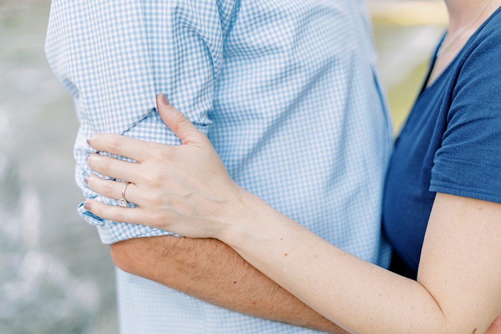 Couple embracing showing off engagement ring