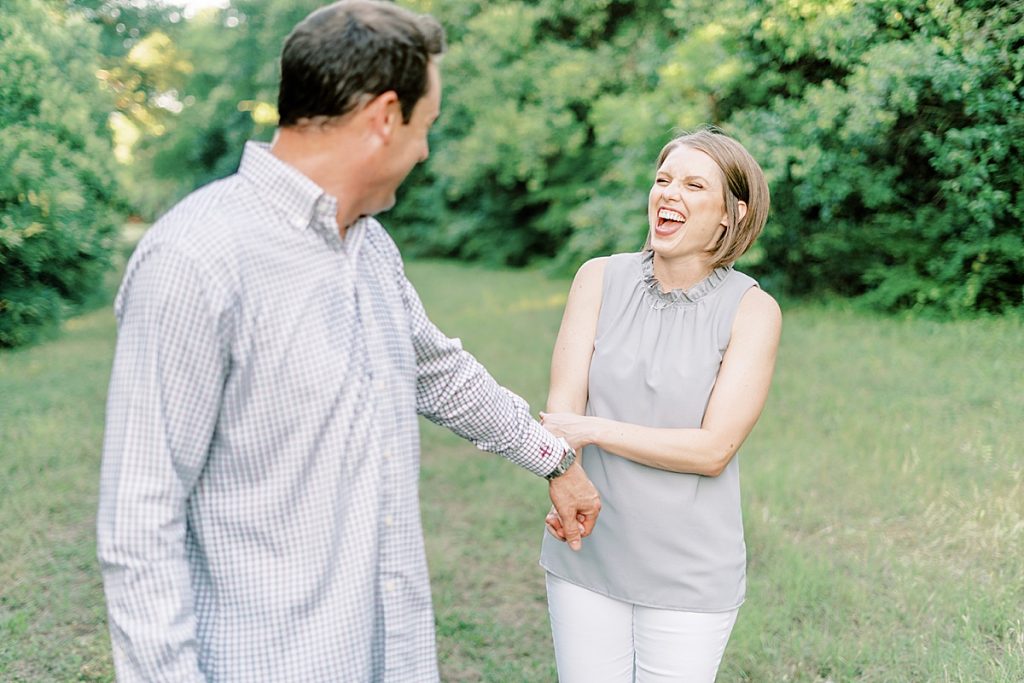 Guy pulling girl along while she laughs at their Airfield Falls Engagement Session 