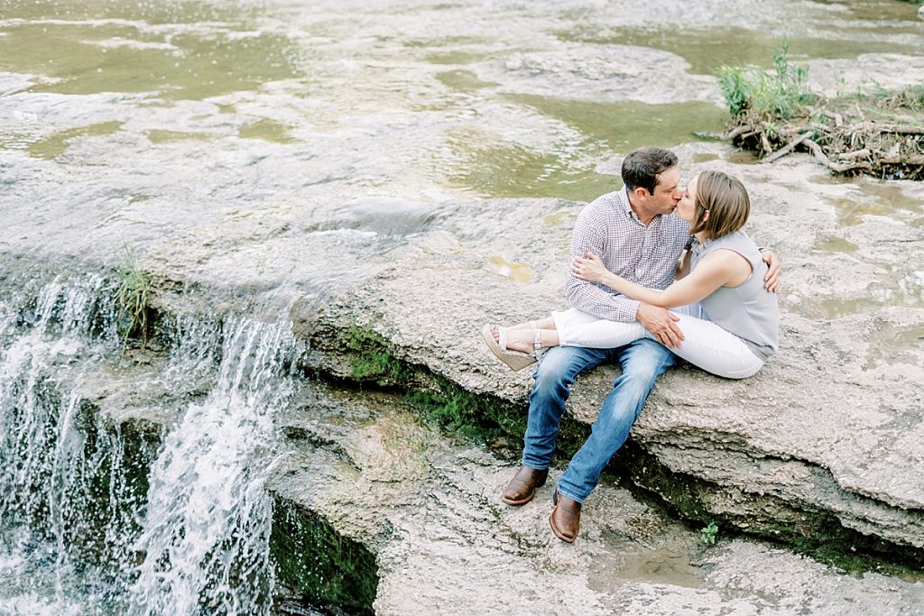 Couple cuddling and laughing on rocks at Airfield Falls