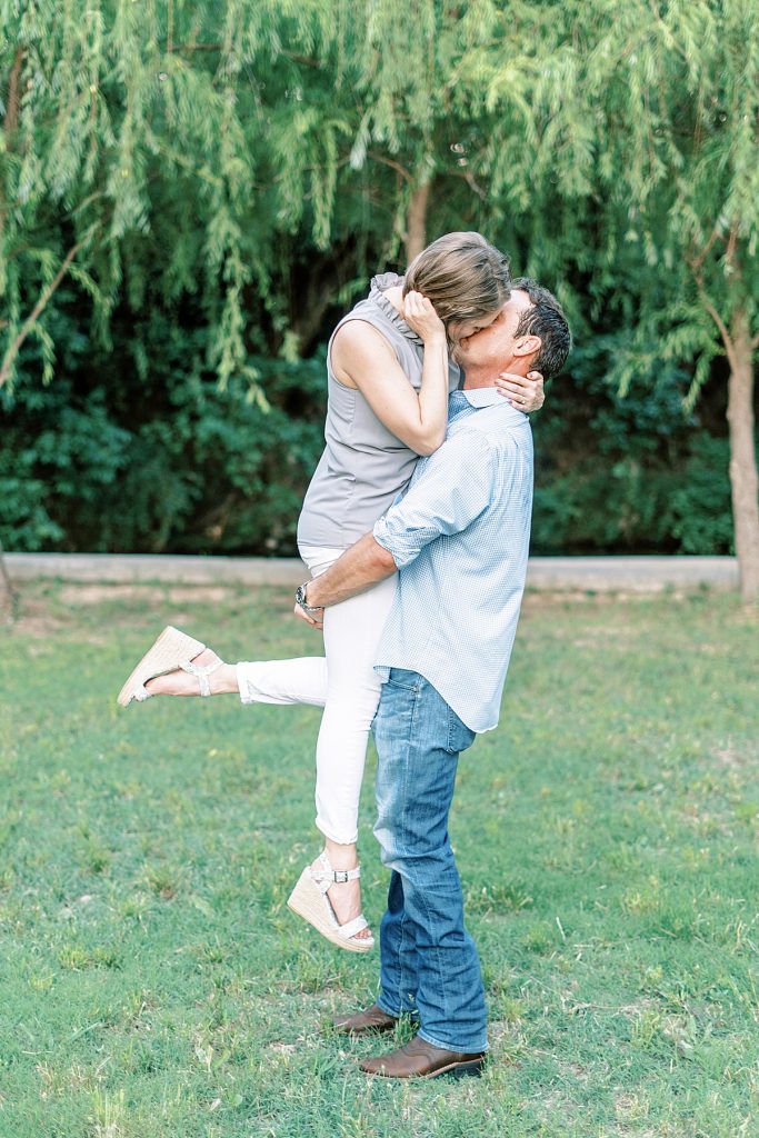 Guy picks up girl and kisses her romantically during their Airfield Falls Engagement Session 
