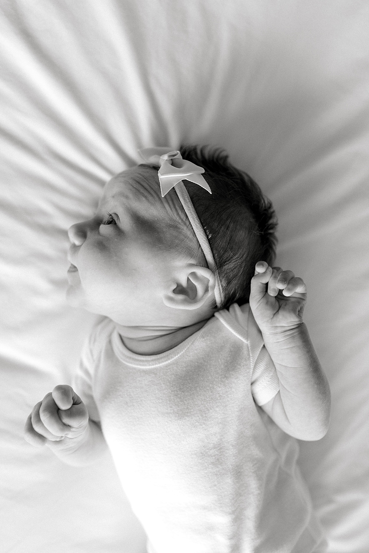 BW baby laying on bed in Fort Worth Lifestyle Newborn Family Session