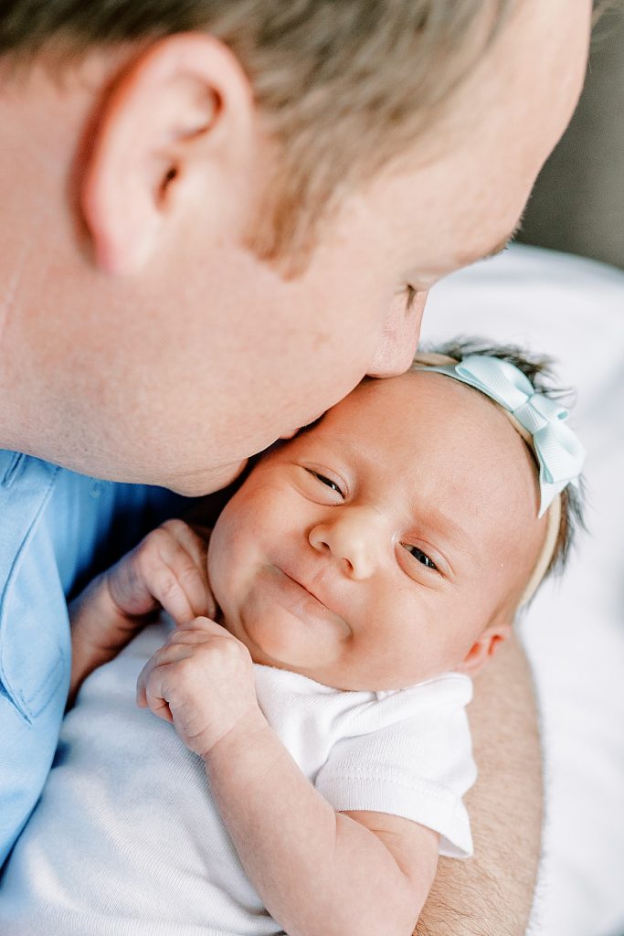 Baby grin while father kisses her| in Fort Worth Lifestyle Newborn Family Session| newborn| Sabel Moments Photography 