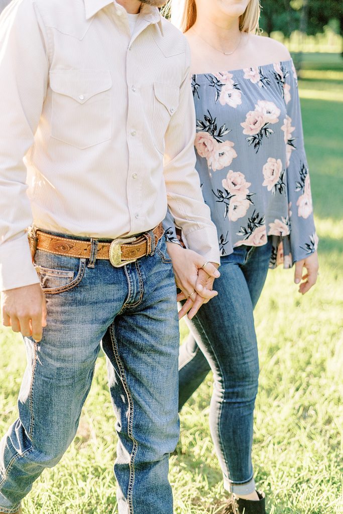 Couple walking and holding hands in field in Trinity Park engagement Fort Worth, Texas