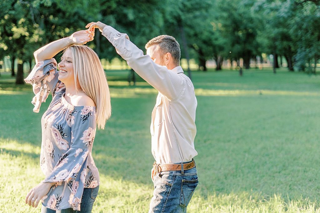 Couple dancing in field during golden hour Fort Worth engagement