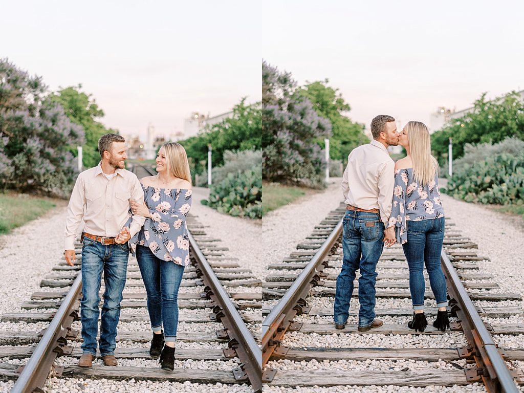 Couple walking on train tracks in Fort Worth stockyard engagement