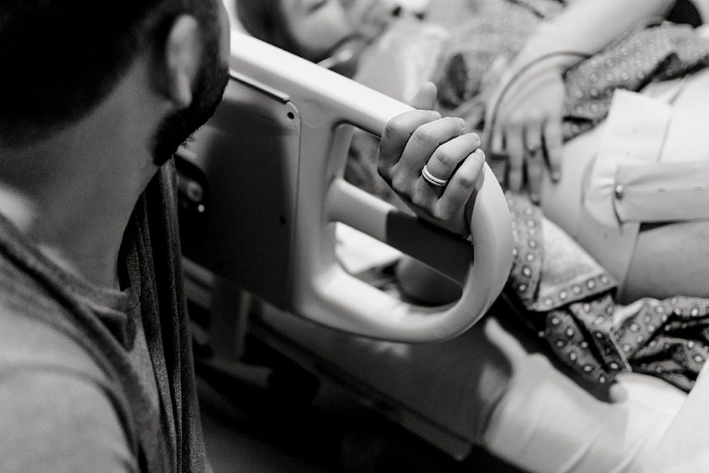 BW mother holding bed rail through contractions for their Texas Health Natural Birth