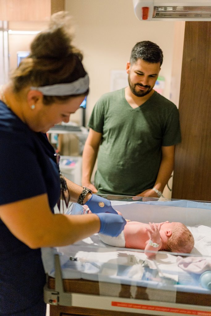 Father watching as newborn gets measured at Texas Health Presbyterian Hospital