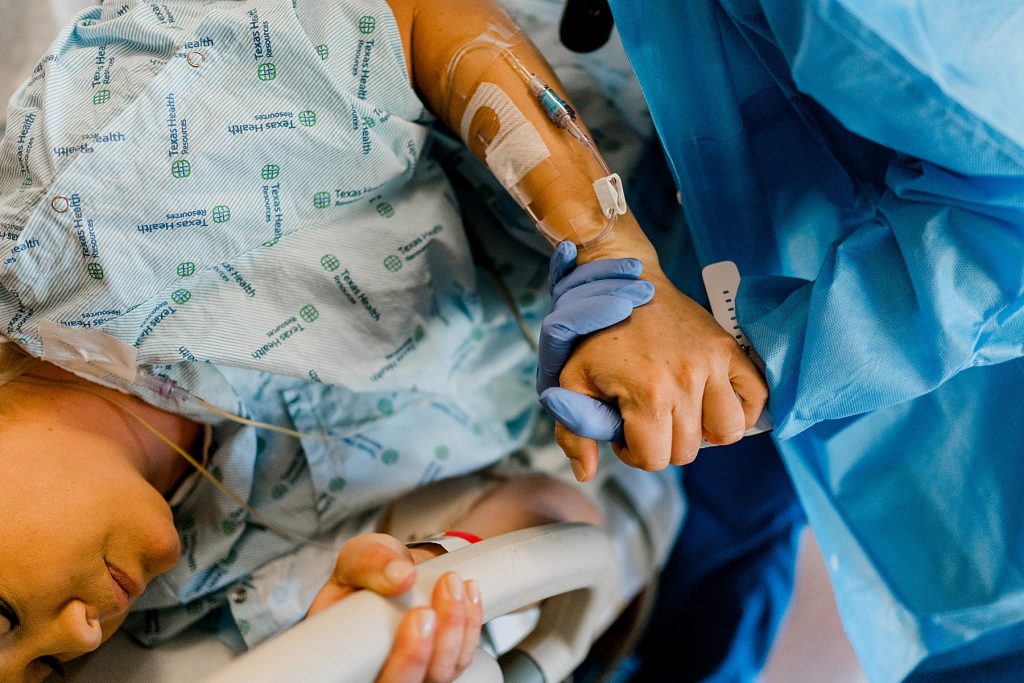 Nurse holding mother's hand through contractions at Health Harris Methodist Hospital 