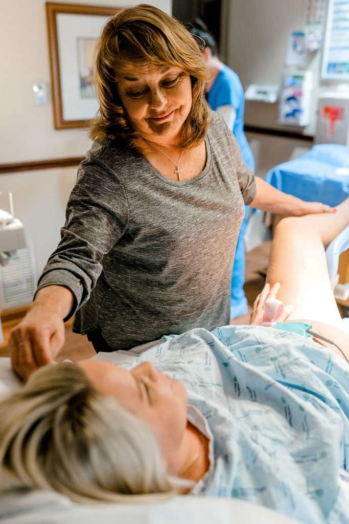 Mother comforting woman through labor and delivery