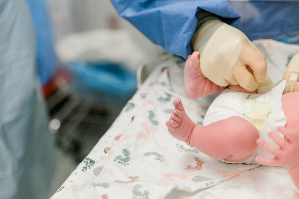 nurse puts diaper on newborn