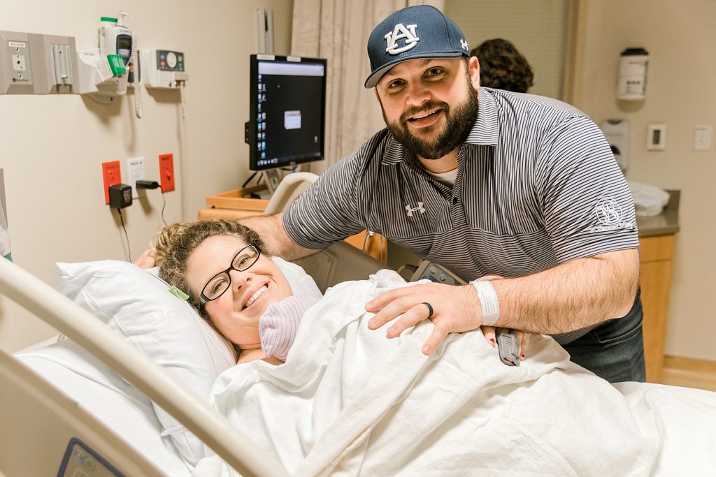 Parents smiling holding newborn at hospital after their Baylor C-Section Birth