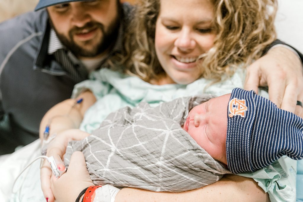 Parents swooning holding newborn baby