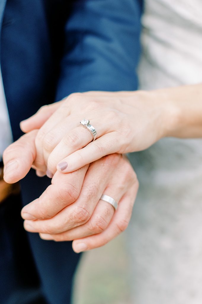 Bride and groom hands showing off wedding rings