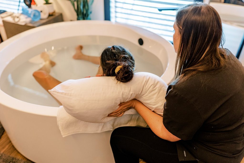 Pregnant woman sitting in bath to help with labor