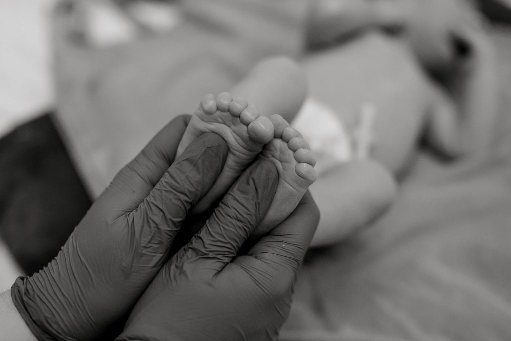 Nurse rubbing newborn baby feet