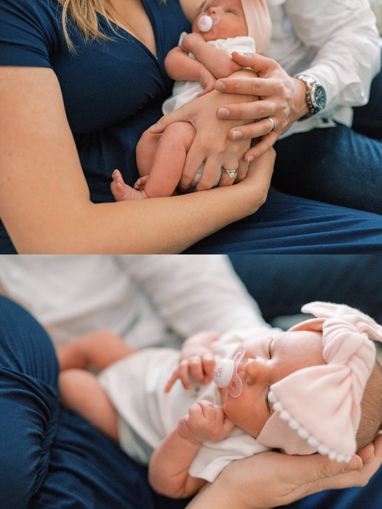 Parents cuddling newborn baby girl wearing pink bow