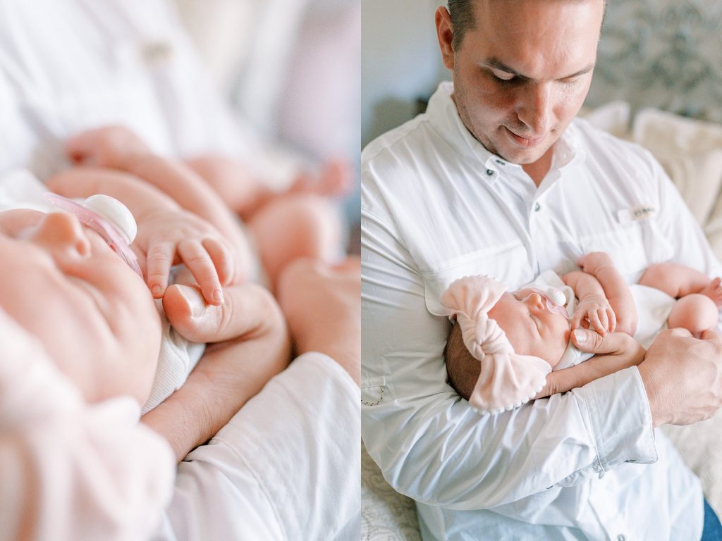 Father cradling newborn baby while baby fingers touch his thumb during her lifestyle newborn session 