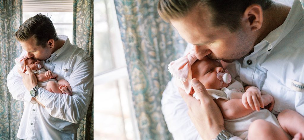 Father holding newborn baby girl and kissing her during her lifestyle newborn session 